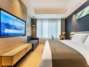 Habitación de hotel con cama y TV de pantalla plana. en LanOu Hotel Ningde Fu'an High-Speed Railway Station en Fu'an