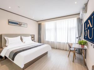 a hotel room with a large bed and a window at LanOu Hotel Langfang Gu'an Daxing Airport Wildlife Park in Langfang