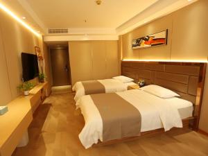 een hotelkamer met 2 bedden en een televisie bij LanOu Hotel Impressions of Taipei Xiantao City in Xiantao