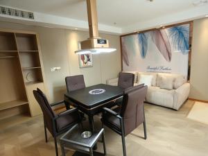 een woonkamer met een tafel en stoelen en een bank bij LanOu Hotel Impressions of Taipei Xiantao City in Xiantao