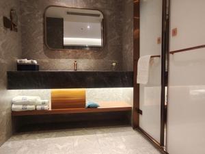 a bathroom with a sink and a mirror at LanOu Hotel Lianyungang Donghai High-speed Railway Station Crystal City in Donghai