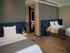 a hotel room with two beds and a bathroom at LanOu Hotel Ordos Jungar Banner Jungar Street in Jungar