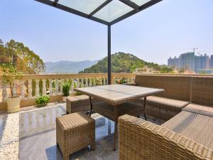 a patio with a table and chairs on a balcony at Jiari Meidi Hotel Chaozhou Hanshan Normal University in Chaozhou