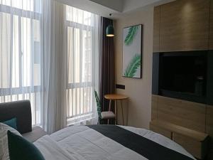 een slaapkamer met een bed en een flatscreen-tv bij Thank Inn Chain Yingtan Guixi Eagle Avenue Shengfeng in Guixi
