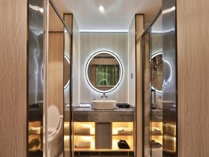 a bathroom with a sink and a mirror at Jiari Meidi Hotel Chaozhou Hanshan Normal University in Chaozhou