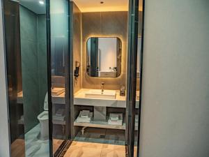 a bathroom with a sink and a mirror at Thank Inn Chain Kashgar Ancient City Wanda in Kashgar