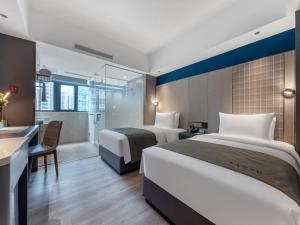 a hotel room with two beds and a desk at LanOu Hotel Shenzhen Luohu Ruipeng Building in Shenzhen