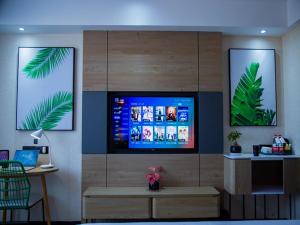 a living room with a flat screen tv on a wall at Thank Inn Chain Kashgar Bachu Junmin Road Balchuk Town in Pa-ch'u-hsien