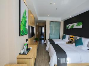 a hotel room with two beds and a desk at Thank Inn Chain Xianyang Renmin Road Central Plaza in Xianyang