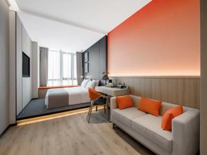 una camera d'albergo con divano e letto di LanOu Hotel Changsha Wuyi Square a Changsha