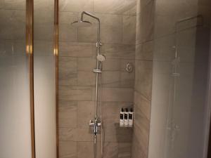 La salle de bains est pourvue d'une douche avec une porte en verre. dans l'établissement LanOu Hotel Ordos Jungar Banner Jungar Street, à Jungar