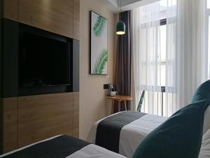 een hotelkamer met 2 bedden en een flatscreen-tv bij Thank Inn Chain Yingtan Guixi Eagle Avenue Shengfeng in Guixi