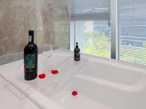 a bottle of wine and two glasses on a bath tub at LanOu M Hotel Shangxing Luxun's Hometown in Shaoxing