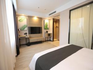 a bedroom with a bed and a desk and a television at Thank Inn Chain Beijing Fanshan Chengguan Town Fangshan Red Scarf Park in Fangshan