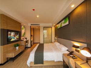 宜昌市にあるThank Inn Chain Yichang Sanxia Airportの大型ベッドとテレビが備わるホテルルームです。