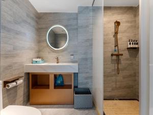 een badkamer met een wastafel en een spiegel bij LanOu Hotel Shenzhen Luohu Ruipeng Building in Shenzhen