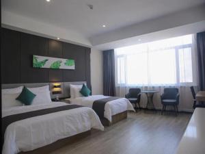 a hotel room with two beds and a table and chairs at Thank Inn Chain Yulin Yuyang Jinsha Road in Yulin