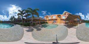 a resort with three large swimming pools in front of a building at Alunsina Hotel and Spa in Roxas City