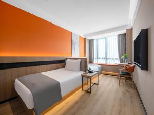 a hotel room with a bed and a television at LanOu Hotel Changsha Wuyi Square in Changsha