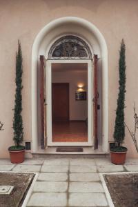 uma entrada para um edifício com duas árvores em vasos em The Tuscany Rose em Pistoia