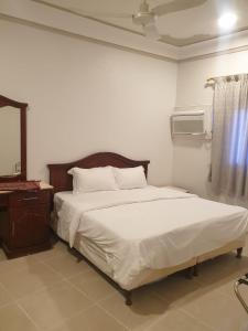 a bedroom with a bed and a mirror and a window at شقق مأوى الدانة للشقق المخدومة in Ţubarjal