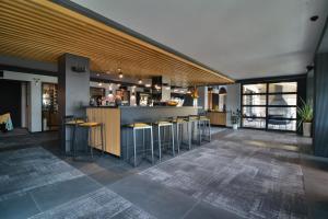 a lobby with a bar with stools in a building at Boutique Hotel by BlackSeaRama in Balchik