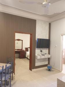 a room with a bedroom with a bed and a mirror at شقق مأوى الدانة للشقق المخدومة in Ţubarjal