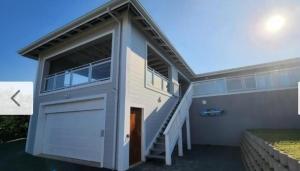 彭宁顿House17Jagger on Cod的一座带车库门和楼梯的房子