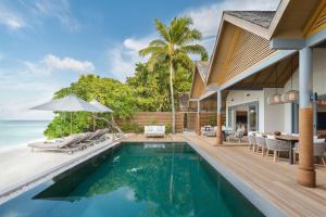 a house with a swimming pool next to the ocean at Vakkaru Maldives in Baa Atoll