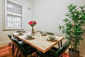 a dining room table with chairs and flowers on it at Vibrant House at the Center of Chippendale 2 E-Bikes Included in Sydney