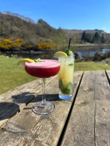 a cocktail and a drink sitting on a wooden table at Tigh an Truish Inn in Oban