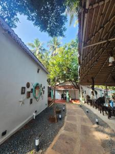 a patio of a building with benches and trees at Casa Happy Dervish, 2mins away from the beach in Anjuna