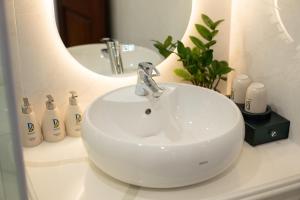 um lavatório branco na casa de banho com um espelho em Danitel Halong em Ha Long