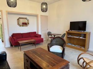 a living room with a red couch and a tv at Auberge Ti'gousket in Guingamp