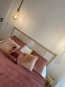1 dormitorio con 1 cama con sábanas y almohadas rojas en Suite 26-Appartement au coeur de Namur, en Namur