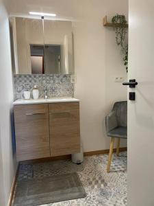 a bathroom with a sink and a mirror and a chair at Suite 26-Appartement au coeur de Namur in Namur