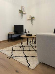 a living room with a table and a couch at Suite 26-Appartement au coeur de Namur in Namur