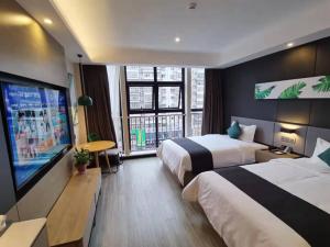 um quarto de hotel com duas camas e uma televisão de ecrã plano em Thank Inn Chain Hami Queen Sky Street em Hami