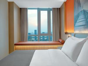 una camera con un grande letto e una finestra di LanOu Hotel Changsha Wuyi Square a Changsha