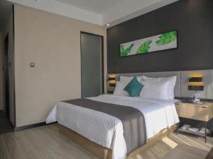 a bedroom with a large white bed and a wall at Thank Inn Chain Yulin Yuyang Jinsha Road in Yulin