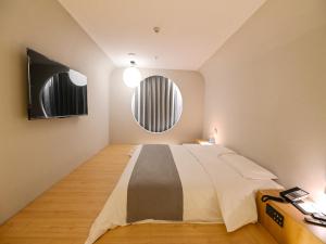 a bedroom with a large bed and a round window at Thank Inn Chain Hotel Loudi City Government Hotel in Loudi