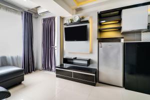 a living room with a refrigerator and a tv at OYO Life 91614 Jarrdin Apartment By Hallo Tidur by Ozi in Bandung