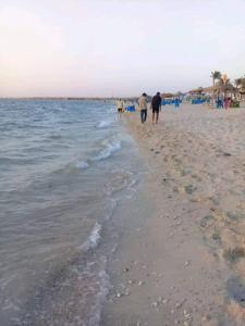 a group of people walking on the beach at قرية النورس مكتب السعد in Ismailia