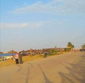 eine Gruppe von Menschen, die am Strand stehen in der Unterkunft قرية النورس مكتب السعد in Ismailia