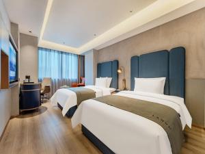 Habitación de hotel con 2 camas y TV en LanOu Hotel Ningde Fu'an High-Speed Railway Station en Fu'an