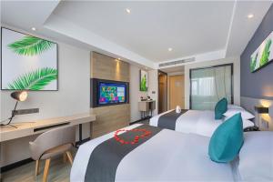 a bedroom with two beds and a desk and a tv at Thank Inn Chain Beijing Fanshan Chengguan Town Fangshan Red Scarf Park in Fangshan