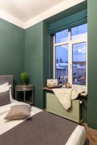 リヴィウにあるAlfa Apartments Halytska 9の緑のベッドルーム(ベッド1台、窓付)