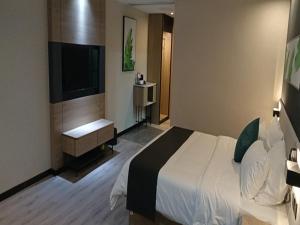 een hotelkamer met een bed en een flatscreen-tv bij Thank Inn Chain Yingtan Guixi Eagle Avenue Shengfeng in Guixi