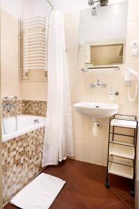 a bathroom with a tub and a sink at Gołębia 8 Residence in Kraków