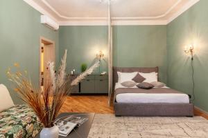 リヴィウにあるAlfa Apartments Halytska 9の緑の壁にベッドが備わるベッドルーム1室